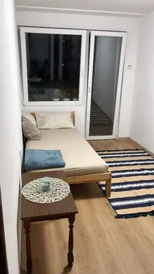 a room with a bed and a table and a window at Stan ARS in Belgrade