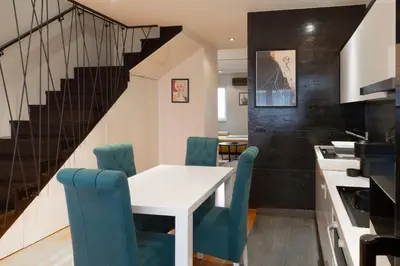 a dining room with a white table and blue chairs at Charming Duplex in Belgrade in Belgrade