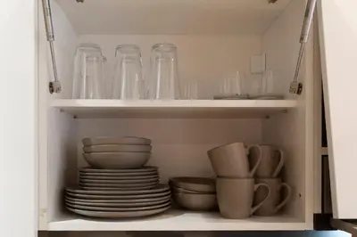 a cupboard filled with glasses and plates and bowls at Charming Duplex in Belgrade in Belgrade