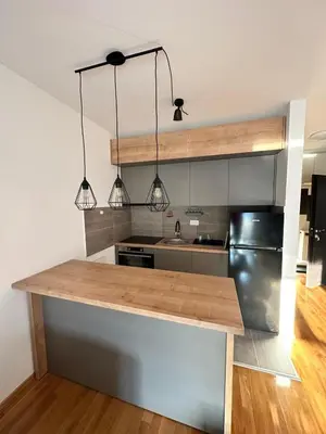 a kitchen with a counter with two lights above it at Apartman Tiffany in Belgrade