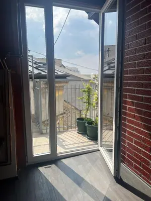 an open sliding glass door to a balcony with plants at Sky Rooftop Huge Apartment in Belgrade