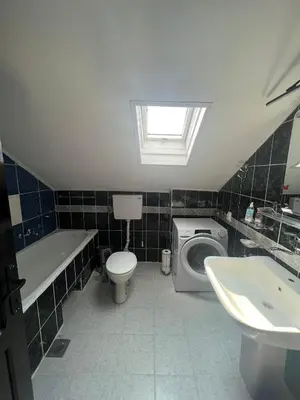 a bathroom with a toilet sink and a washing machine at Sky Rooftop Huge Apartment in Belgrade