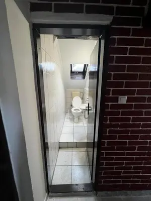 a small bathroom with a toilet in a brick wall at Sky Rooftop Huge Apartment in Belgrade