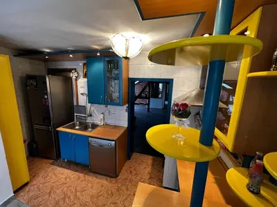 a kitchen with blue and yellow cabinets and a yellow table at Sky Rooftop Huge Apartment in Belgrade