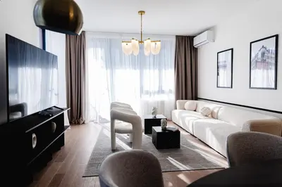 a living room with a white couch and a tv at Aglaya Paris - Lux 2 Bedroom Apartment in Belgrade