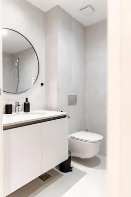 a white bathroom with a toilet and a mirror at Aglaya Paris - Lux 2 Bedroom Apartment in Belgrade