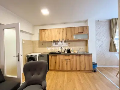 a kitchen with wooden cabinets and a sink and a chair at WATEREFRONT Apartments - Belgrade in Belgrade