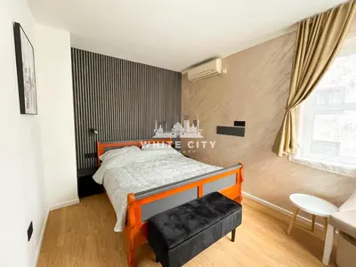 a bedroom with a bed and a chair and a window at WATEREFRONT Apartments - Belgrade in Belgrade