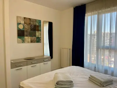 a bedroom with a bed and a window with a view at The Gates 104 in Belgrade