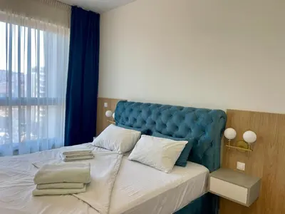 a bed with a blue headboard in a bedroom at The Gates 104 in Belgrade