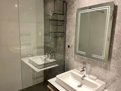 a bathroom with a sink and a mirror and a shower at The Gates 104 in Belgrade
