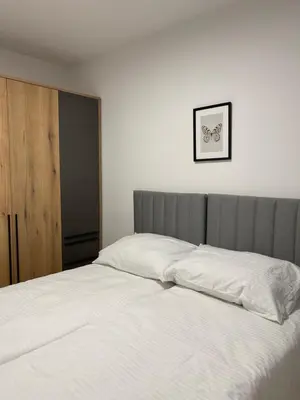 a bed with white sheets in a bedroom at FlyInn Residence in Belgrade
