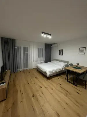 a bedroom with a bed and a table in it at FlyInn Residence in Belgrade