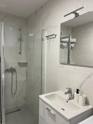 a white bathroom with a shower and a sink at FlyInn Residence in Belgrade