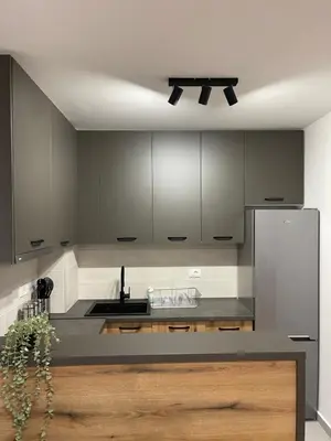 a kitchen with gray cabinets and a stainless steel refrigerator at FlyInn Residence in Belgrade