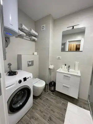 a bathroom with a washing machine and a toilet at FlyInn Residence in Belgrade