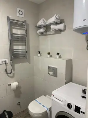a bathroom with a toilet and a washing machine at FlyInn Residence in Belgrade