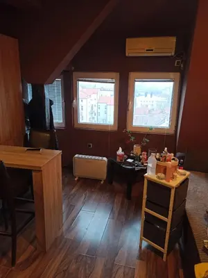 a living room with two windows and a wooden floor at Stan u centru grada za 2 plus 1 osoba in Belgrade