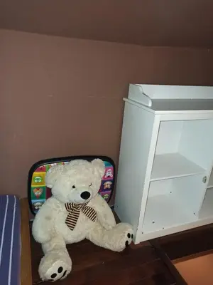 a white teddy bear sitting next to a suitcase at Stan u centru grada za 2 plus 1 osoba in Belgrade