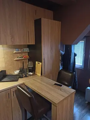 a kitchen with a wooden table and some chairs at Stan u centru grada za 2 plus 1 osoba in Belgrade