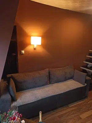 a couch in a living room with a lamp on the wall at Stan u centru grada za 2 plus 1 osoba in Belgrade