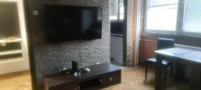 a living room with a table and a flat screen tv at Medo in Belgrade