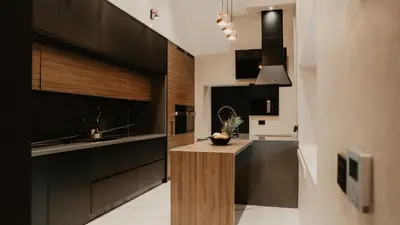 a kitchen with black cabinets and a island in the middle at Diwine Spa House Fruška Gora in Irig