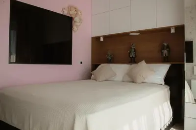 a bedroom with a white bed with a flat screen tv at Diwine Spa House Fruška Gora in Irig