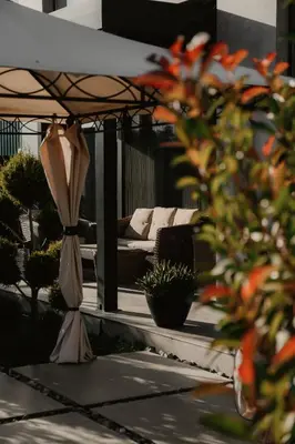 a patio with a couch and an umbrella at Diwine Spa House Fruška Gora in Irig