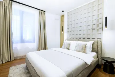 a white bedroom with a large bed and a window at Tasmajdan park, 15 minutes by walk to Knez Mihajlova Centar in Belgrade