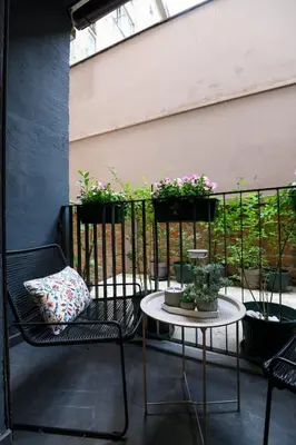 a patio with two chairs and two tables and potted plants at Tasmajdan park, 15 minutes by walk to Knez Mihajlova Centar in Belgrade