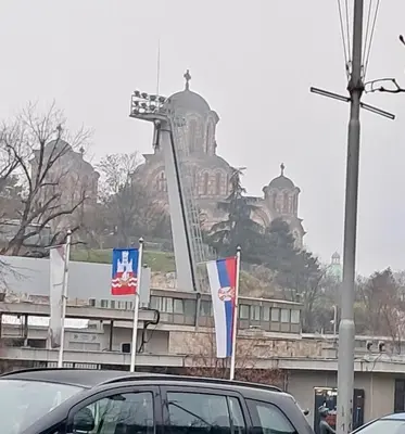 a car parked in front of a building with flags at Tasmajdan park, 15 minutes by walk to Knez Mihajlova Centar in Belgrade