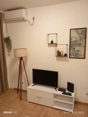 a living room with a flat screen tv on a white cabinet at Apartman Vuk in Obrenovac