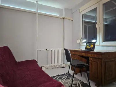 a room with a desk and a chair next to a window at Zante Apartment in Belgrade