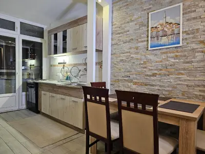 a kitchen with a table and chairs and a brick wall at Zante Apartment in Belgrade