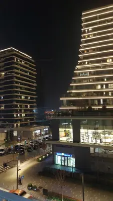 a large building in a city at night at Belgrade Waterfront Terra Apartments in Belgrade