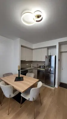 a kitchen with a wooden table and a refrigerator at Belgrade Waterfront Terra Apartments in Belgrade