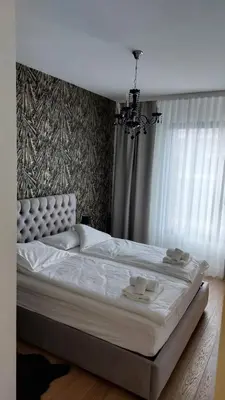 a bedroom with a large white bed with a chandelier at Belgrade Waterfront Terra Apartments in Belgrade