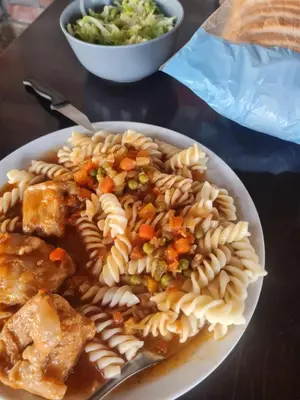 a plate of pasta with meat and vegetables on a table at Vikendica Emily in Kovin