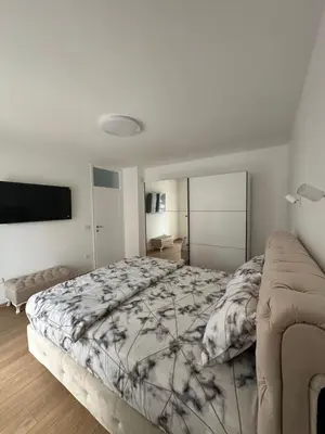 a bedroom with a large bed and a flat screen tv at Apartman Aranđelovac2 in Arandjelovac