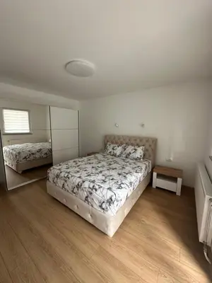 a bedroom with a large bed and a mirror at Apartman Aranđelovac2 in Arandjelovac