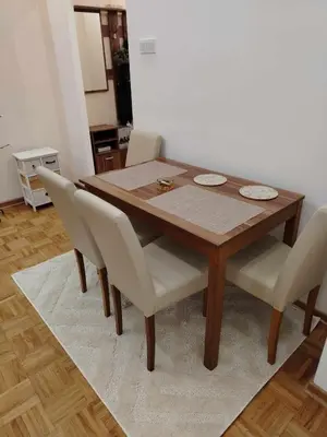 a wooden dining room table with white chairs at Star Apartment Belgrade 1 in Belgrade