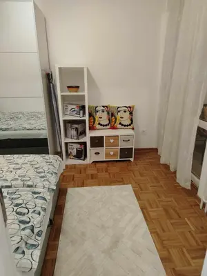 a bedroom with a bed and a shelf with cartoons on it at Star Apartment Belgrade 1 in Belgrade