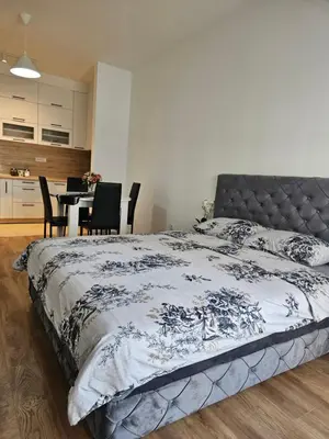 a bedroom with a bed and a table with chairs at MiS Lux in Mladenovac