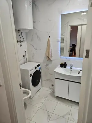 a white bathroom with a washing machine and a sink at MiS Lux in Mladenovac