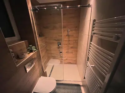 a bathroom with a glass shower with a toilet at Penthouse city center in Belgrade