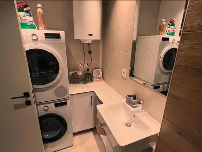 a small bathroom with a washing machine and a sink at Penthouse city center in Belgrade