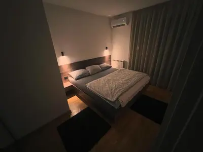 a small bedroom with a bed and a window at Penthouse city center in Belgrade