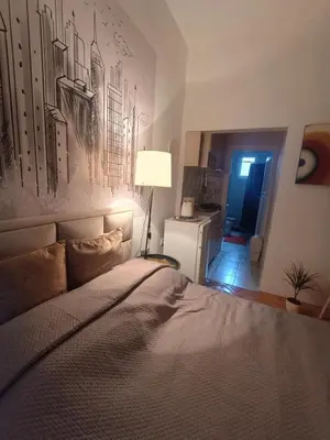 a bedroom with a bed with a painting on the wall at Cosy Central Studio Jana in Belgrade