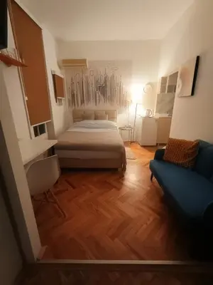 a bedroom with a bed and a blue couch at Cosy Central Studio Jana in Belgrade